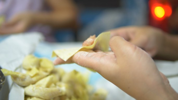 亚洲女性手工制作馄饨和饺子馅。