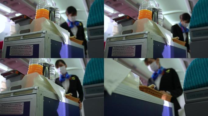 带口罩的空姐为乘客提供食物。从乘客看着空姐的角度拍摄视频。