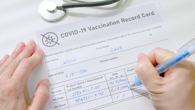 女性写接种记录卡填表疫情疫苗接种信息