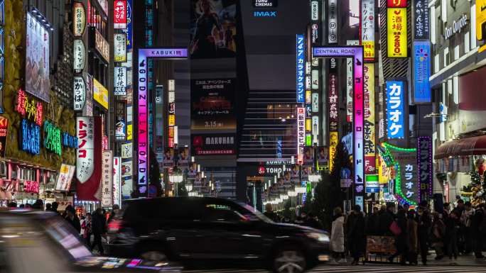 日本东京市，夜间新宿4K时间的流逝，人群不明，行人走在与汽车交通交叉的街道上。日本文化与购物霓虹街概