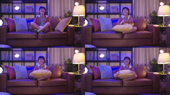 在家里客厅的沙发上选择电视节目，在沙发上使用遥控器观看电视节目
