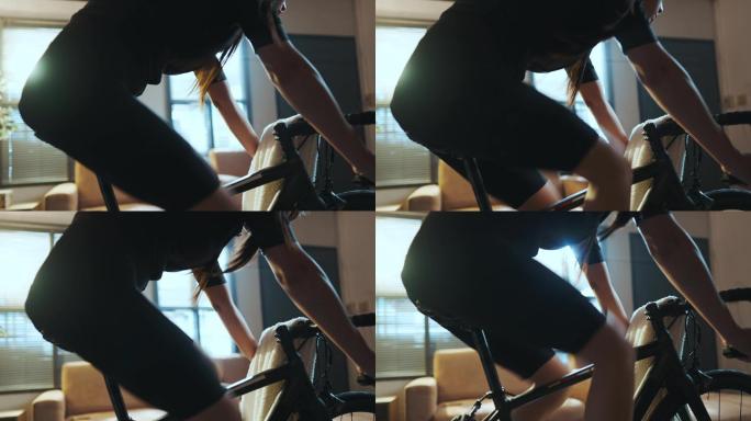 亚洲女自行车手。她正在屋里锻炼。通过在教练机上骑自行车和玩在线自行车游戏
