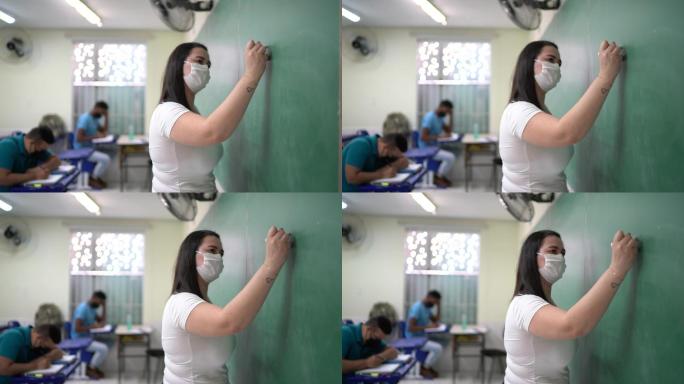 戴口罩的老师在黑板上写字