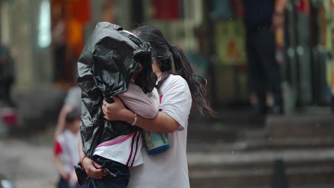 台风过境登陆暴雨过后 一位母亲抱着孩子