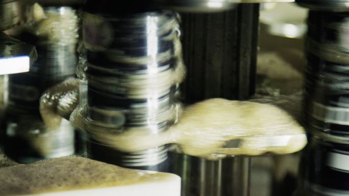 一台旋转制罐机通过在室内制造设施中旋转铝罐来密封铝罐