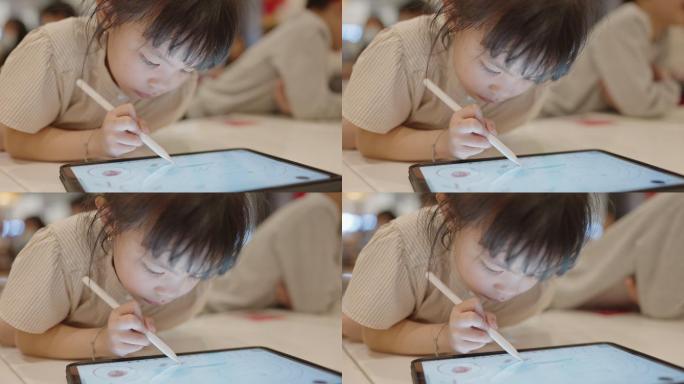 亚洲小女孩和她的弟弟在数字平板电脑上使用数字铅笔画画，亚洲家庭生活方式与技术设备概念