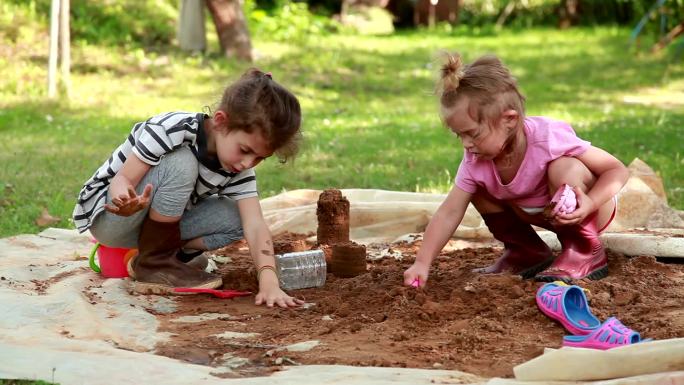 两个小女孩在后院玩沙子