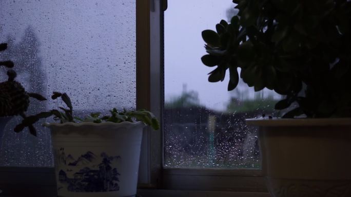 透过农村房子的窗户看外面下雨