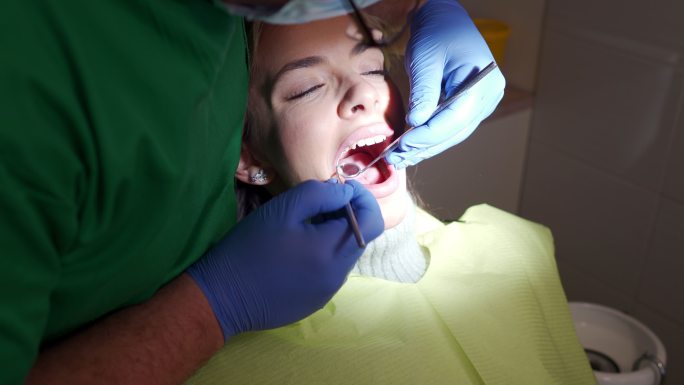 每月对照期间，男性牙医检查女性患者的口腔