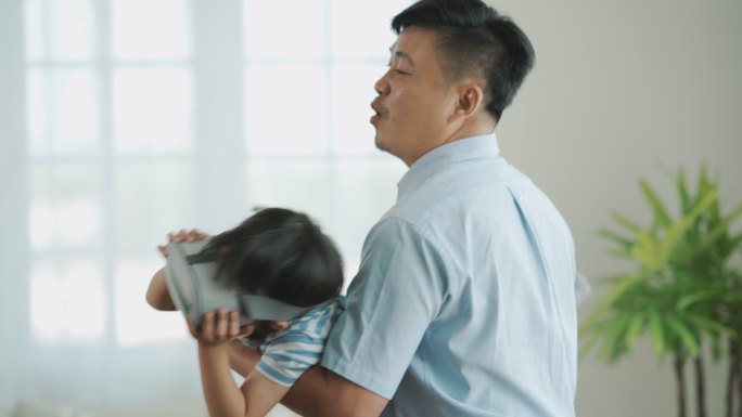 亚洲父亲教女儿使用VR虚拟现实眼镜