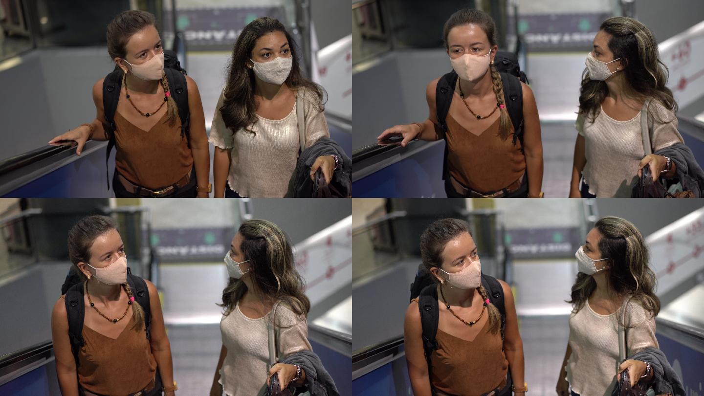 冠状病毒大流行期间，商场扶梯上的妇女戴着防护面罩