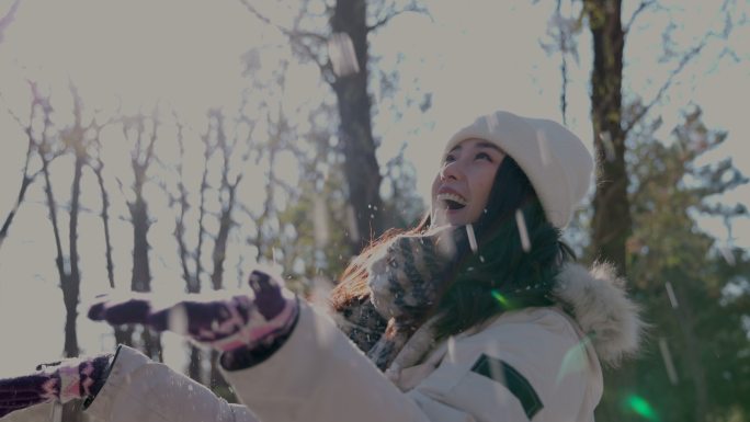 快乐的青年女人在雪地里玩耍