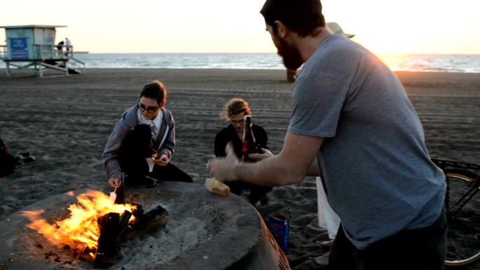 朋友们聚集在海滩篝火旁