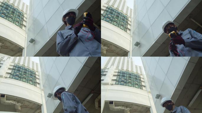 亚洲女技师检查员检查大楼外的平板电脑图表。相机拍摄为ant视图