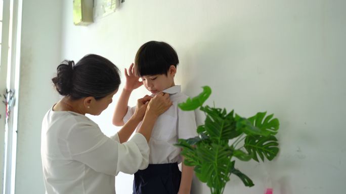 一位亚洲资深女子为她的孙子上学做准备