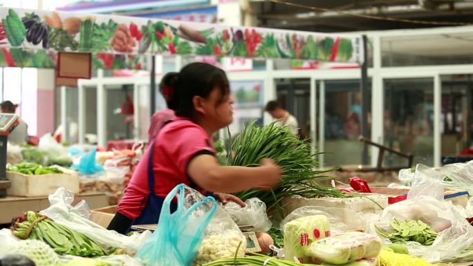 菜市场上的早市群众在购买蔬菜