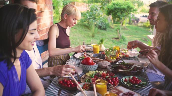 在一个清新的夏日，一群朋友在花园派对上享用美食