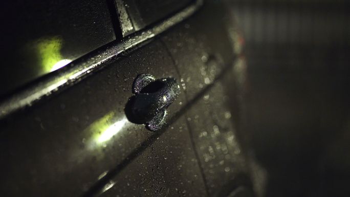 夜间停车场汽车上的雨滴