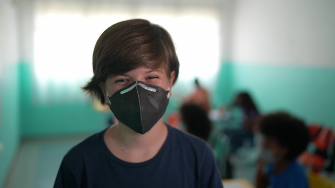 一个男孩在教室里戴口罩的肖像