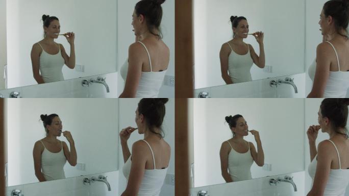 年轻女子一边刷牙一边看着镜子