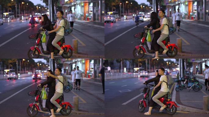 街上情侣骑一辆共享电动车