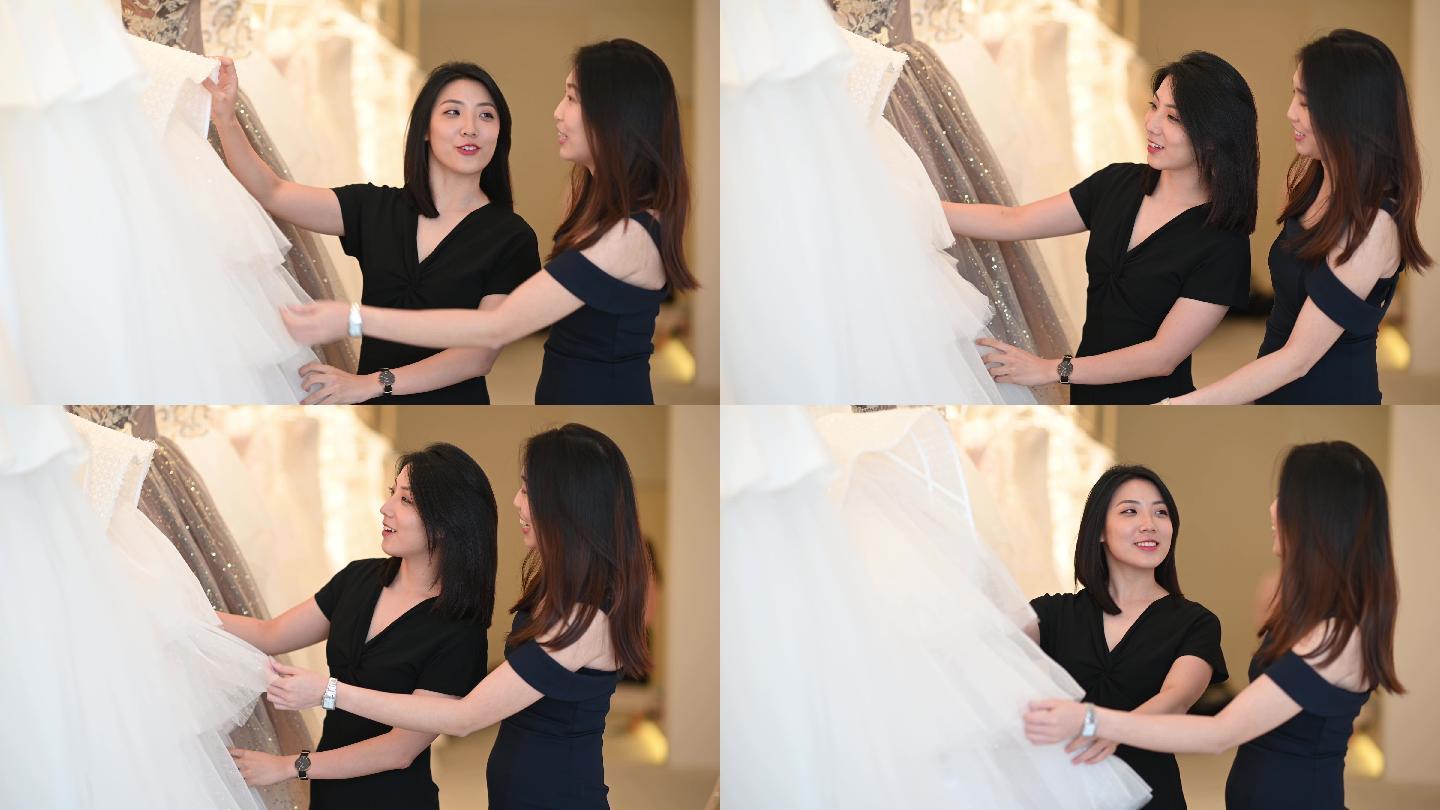 中国亚裔女新娘和伴娘在婚纱店寻找完美的婚纱礼服