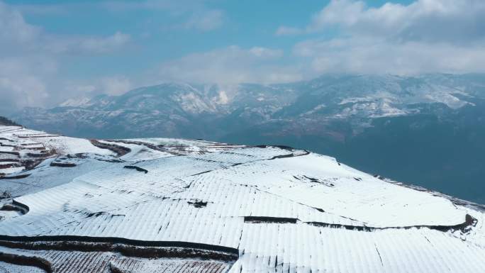 冬季白雪覆盖山川田野农田庄稼远处连绵雪山
