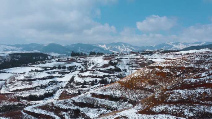 冬季白雪覆盖红土地山川田野远处连绵雪山