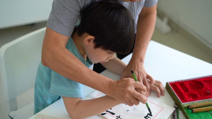 亚洲资深女子在家教孙子中国传统书法