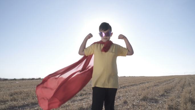 穿超级英雄服装的男孩看起来强壮而自豪