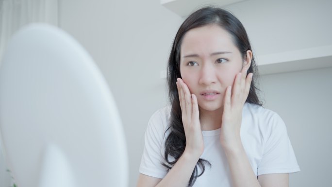 亚洲年轻女性担心面部皮肤病和对化妆品中的类固醇过敏。皮肤敏感，面部晒伤导致面部发红。皮肤问题与美容。