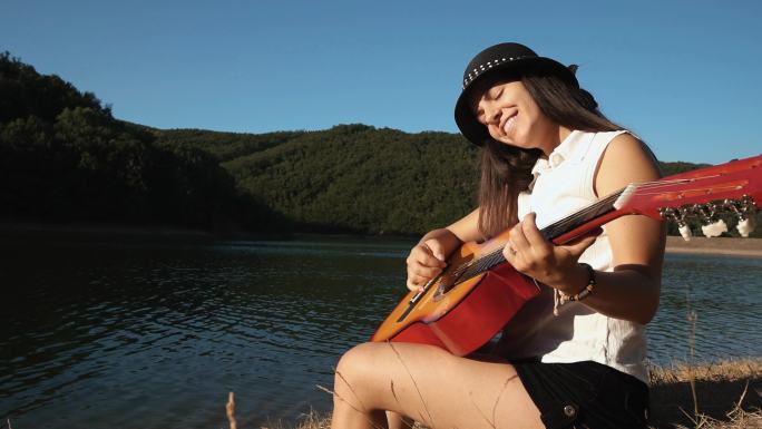 湖岸弹吉他的女人美女弹琴