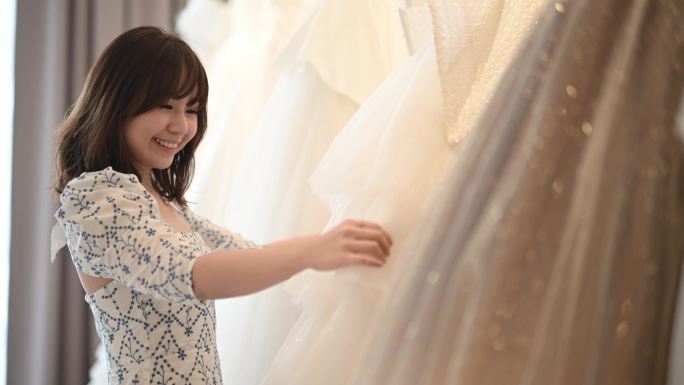 中国亚裔女新娘在婚纱店寻找完美婚纱