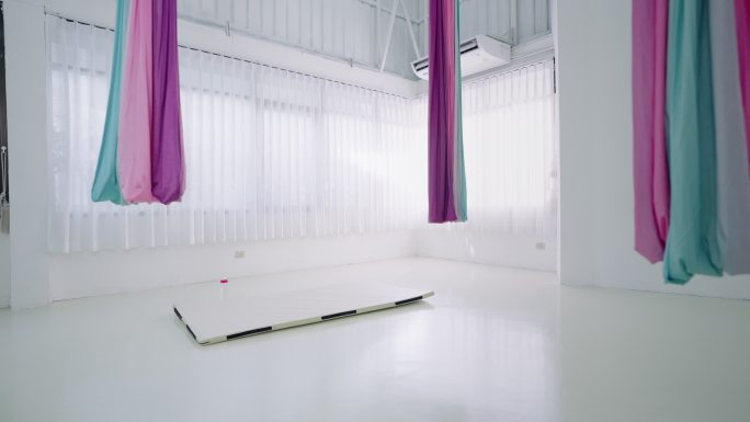 空空的飞行瑜伽白色工作室，空空的空中瑜伽训练室内部，健身房内空空的飞行瑜伽室，带吊床和瑜伽垫，健身房