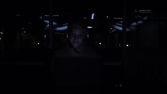 工作区中的成年女性，带着电源和灯光完成笔记本电脑商务视频系列中的任务