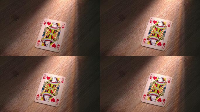红心皇后扑克牌掉落在木桌上。SM