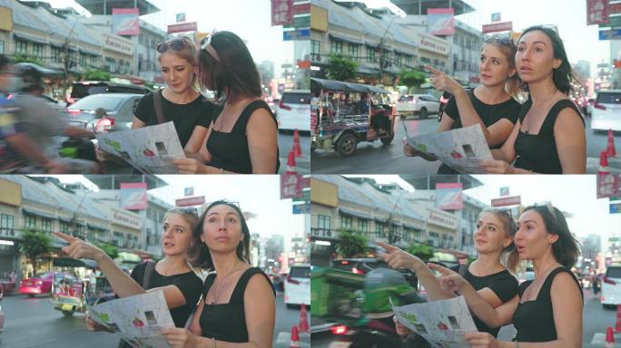两位年轻的旅游女性在曼谷探索时使用地图进行讨论。