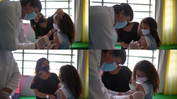 女童与母亲在接种中心接种疫苗