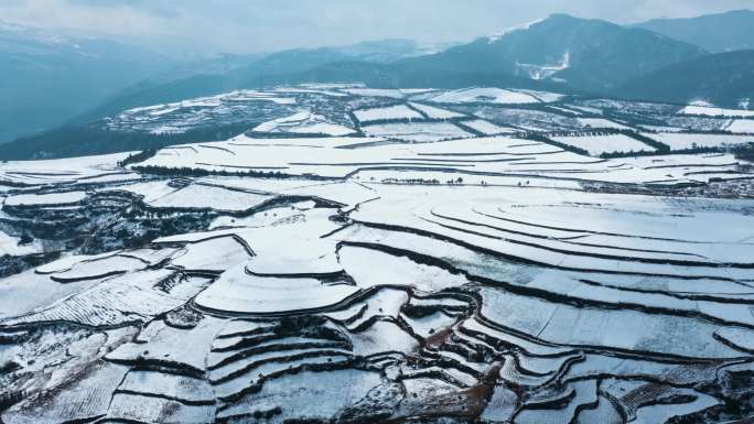 冬季白雪覆盖山川线条明显田野远处连绵雪山