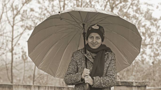 雨季印度妇女手拿雨伞
