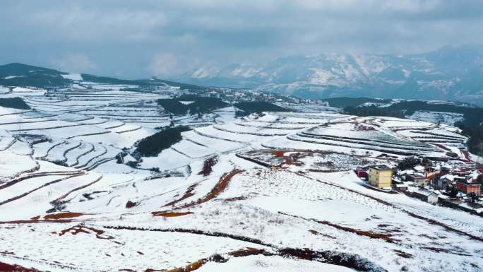 冬季白雪覆盖山川田野农村远处连绵雪山
