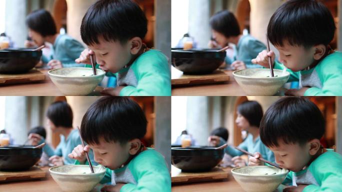 男孩用筷子吃米粉小孩吃饭小孩吃面