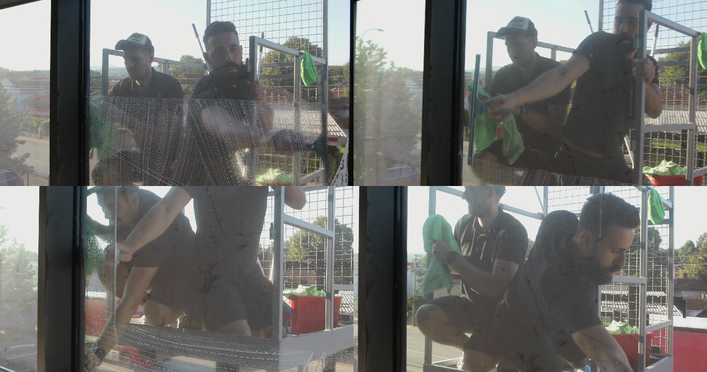 手工工人在玻璃幕墙建筑上清洗窗户