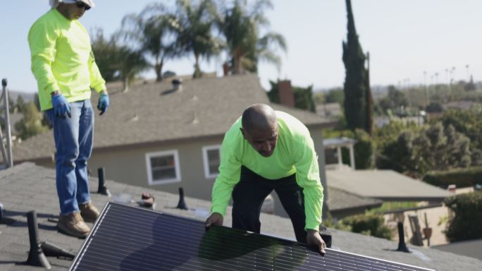 加利福尼亚州住宅屋顶安装太阳能电池板的工人团队