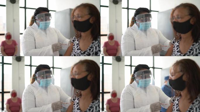 戴口罩接种疫苗的老年妇女