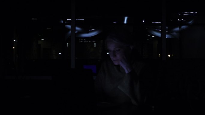 工作区中的成年女性，带着电源和灯光完成笔记本电脑商务视频系列中的任务