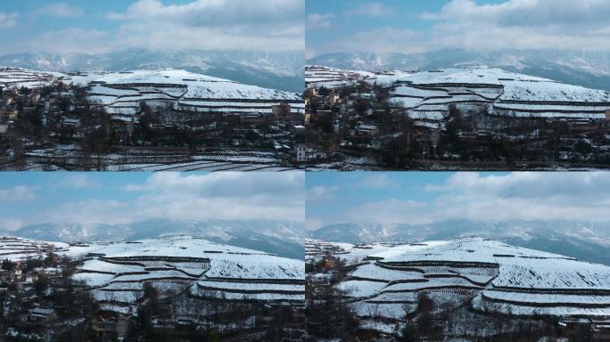 冬季阳光晴天白雪覆盖田野农村远处连绵雪山