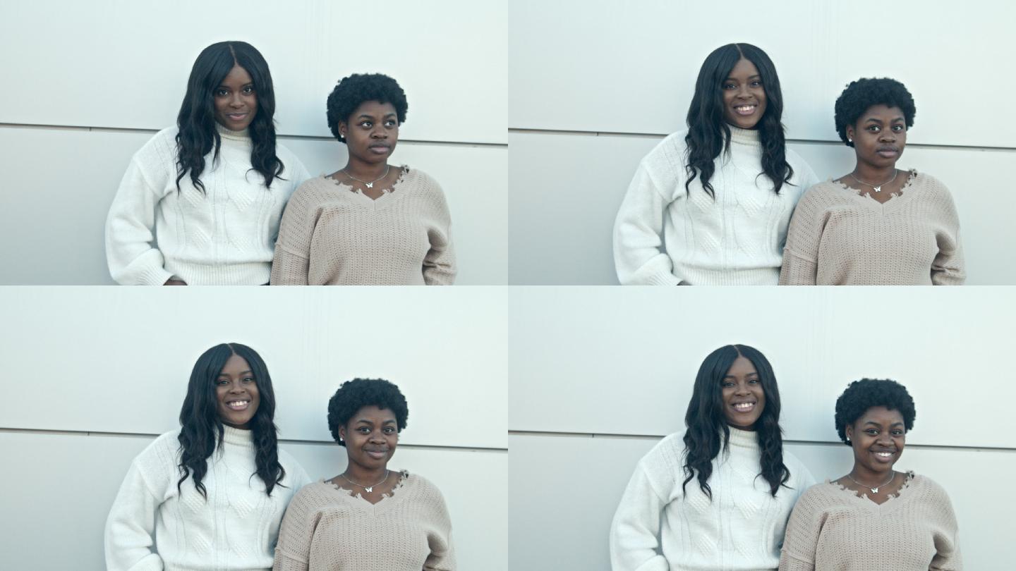 两位年轻貌美的非裔美国/海地女性朋友在市中心摆姿势进行精彩对话