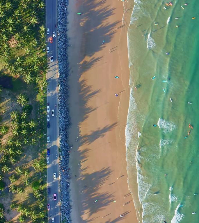 航拍竖版海南万宁日月湾海浪沙滩与公路