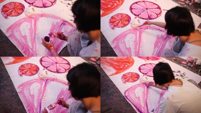 女艺术家，在画布上用红色/紫色颜料画水果